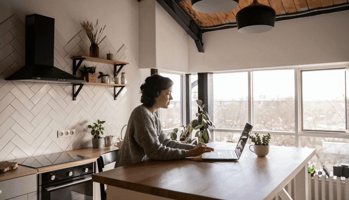 Arbeitnehmende sitzt in ihrer Küche im Homeoffice