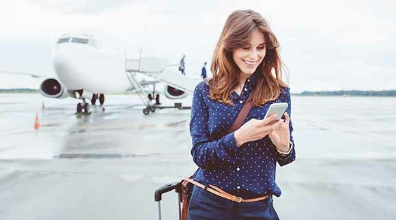 Frau mit Smartphone auf Flugplatz Business Trip auf dem Flugfeld