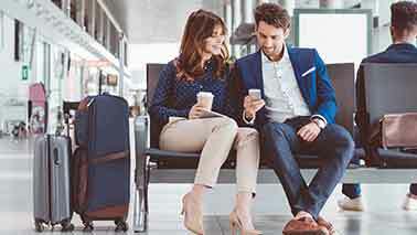 Ein Pärchen sitzt im Flughafen am Check In