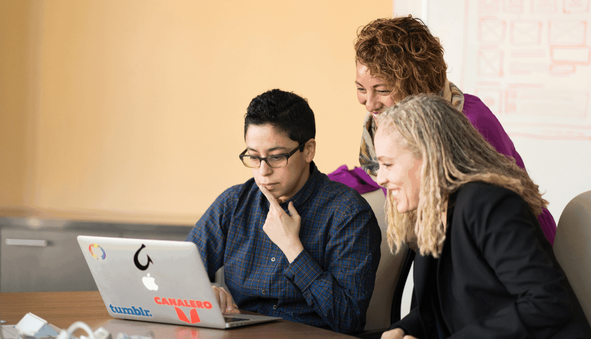 Entwickler-Team vor Laptop zur Besprechung einer IT-Architektur