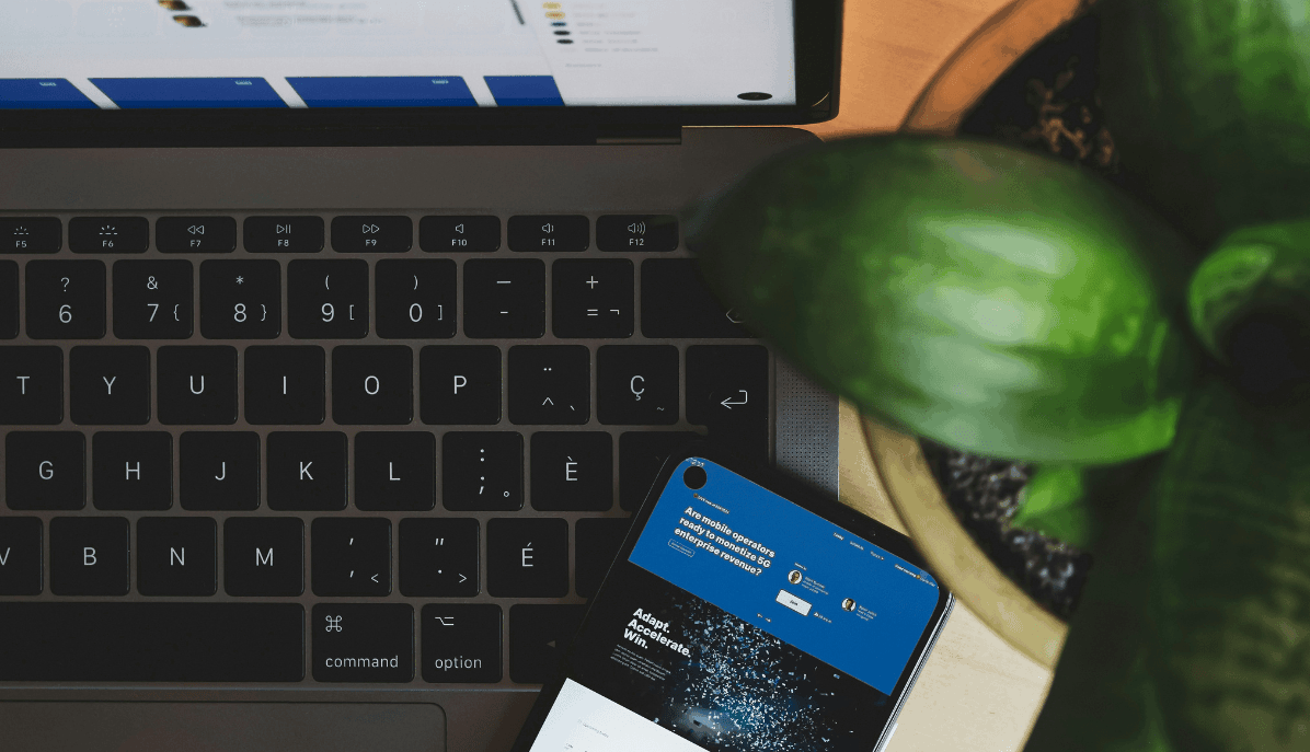 Laptop und Smartphone auf einem Schreibtisch