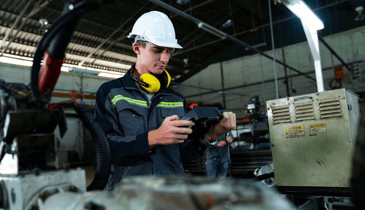 Fabrikarbeiter kontrolliert eine Werksmaschine - Industrie 4.0 wird gelebt