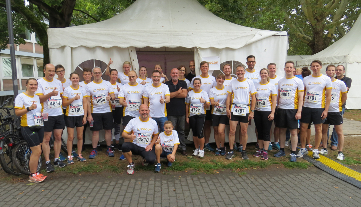 Das komplette Rocon-Team (Frauen, Männer und teilweise auch Kinder der Mitarbeiter) lächelnd beim Firmenlauf in Mainz