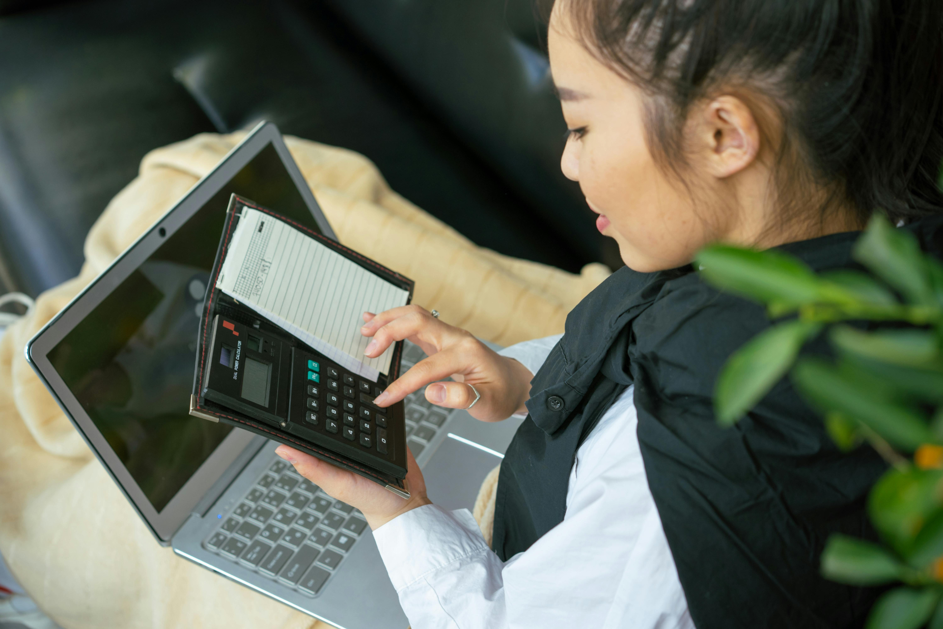 Frau vor Laptop prüft ihre Reisekostenabrechnung