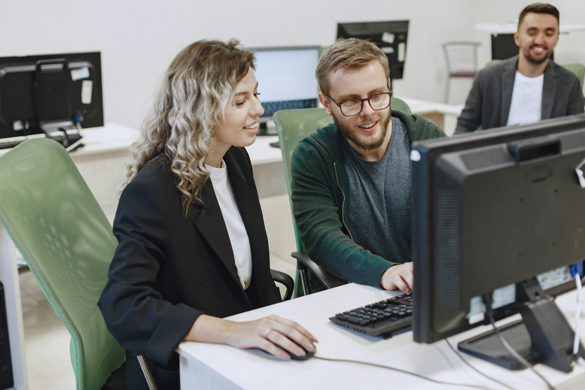 Kollegen bei der Einarbeitung in eine neue Software am PC