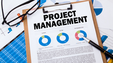 Ein Klemmbrett auf dem Projektmanagement drauf steht