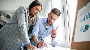 Projektmanagement Meeting bei dem sich ein Mann und eine Frau unterhalten
