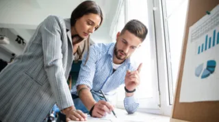 Projektmanagement Meeting bei dem sich ein Mann und eine Frau unterhalten
