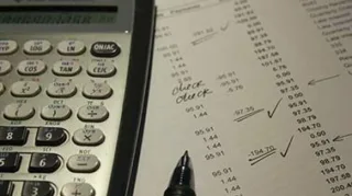 Ein dargestellter Taschenrechner liegt auf einem Stück Papier beim Accounting Jahresabschluss