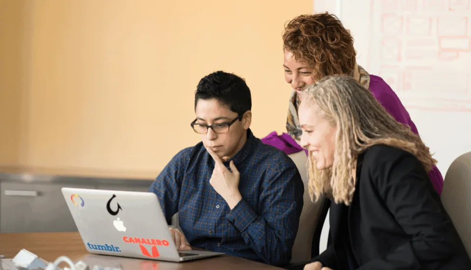 Entwickler-Team vor Laptop zur Besprechung einer IT-Architektur