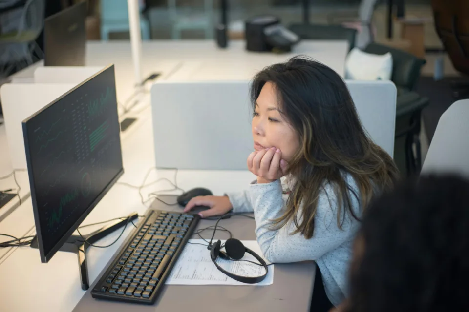 Mitarbeiterin arbeitet mit KI am PC