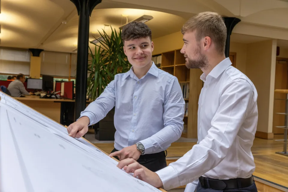 2 Mitarbeiter beraten sich vor einem Whiteboard zur Sicherung der Datenqualität