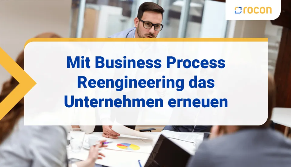 Personen sitzen am Besprechungstisch und diskutieren. Viele Dokumente auf dem Tisch.