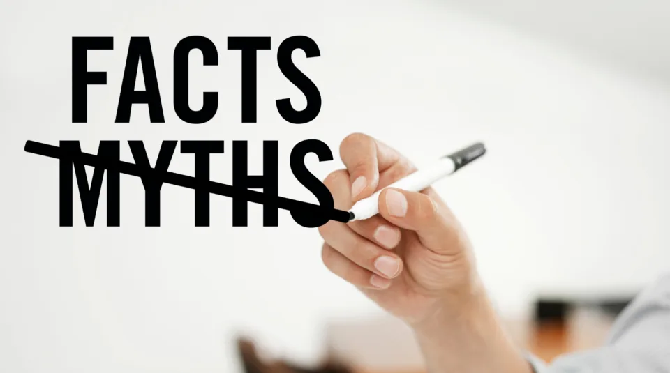 Menschliche Hand hat einen schwarzen Stifft in der Hand, mit dem das Wort "Myth" (dt. Mythen) durchgestrichen ist und das darüber liegende Wort "Facts" im Vordergrund steht